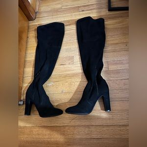 Woman’s thigh high heeled suede boots with zipper closure on the ankles.